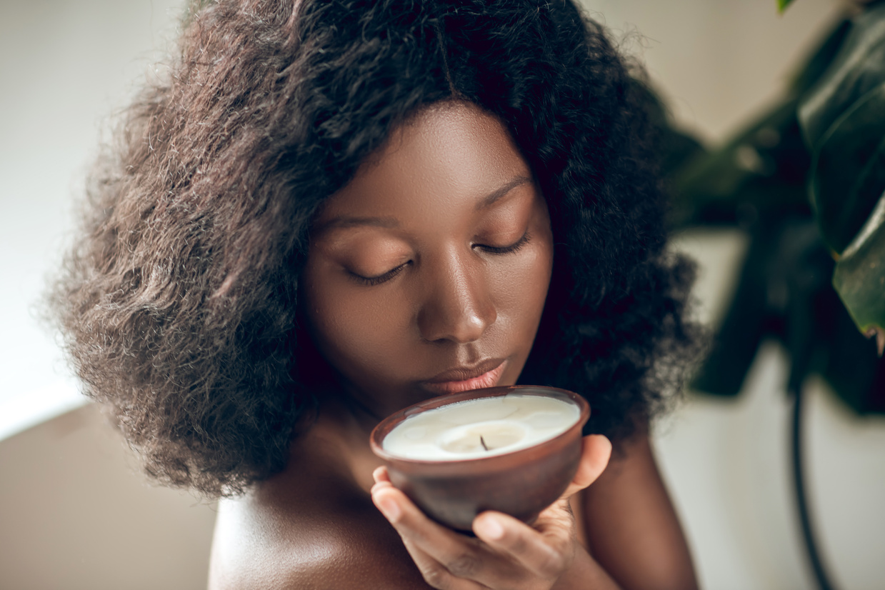 Beautiful Woman Smelling a Scented Candle